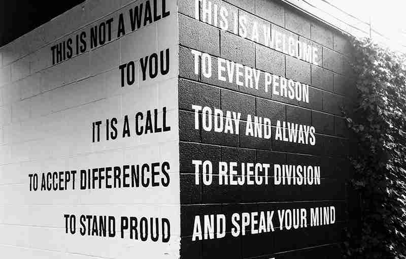 A black and white photo of a wall with a quote on it.
