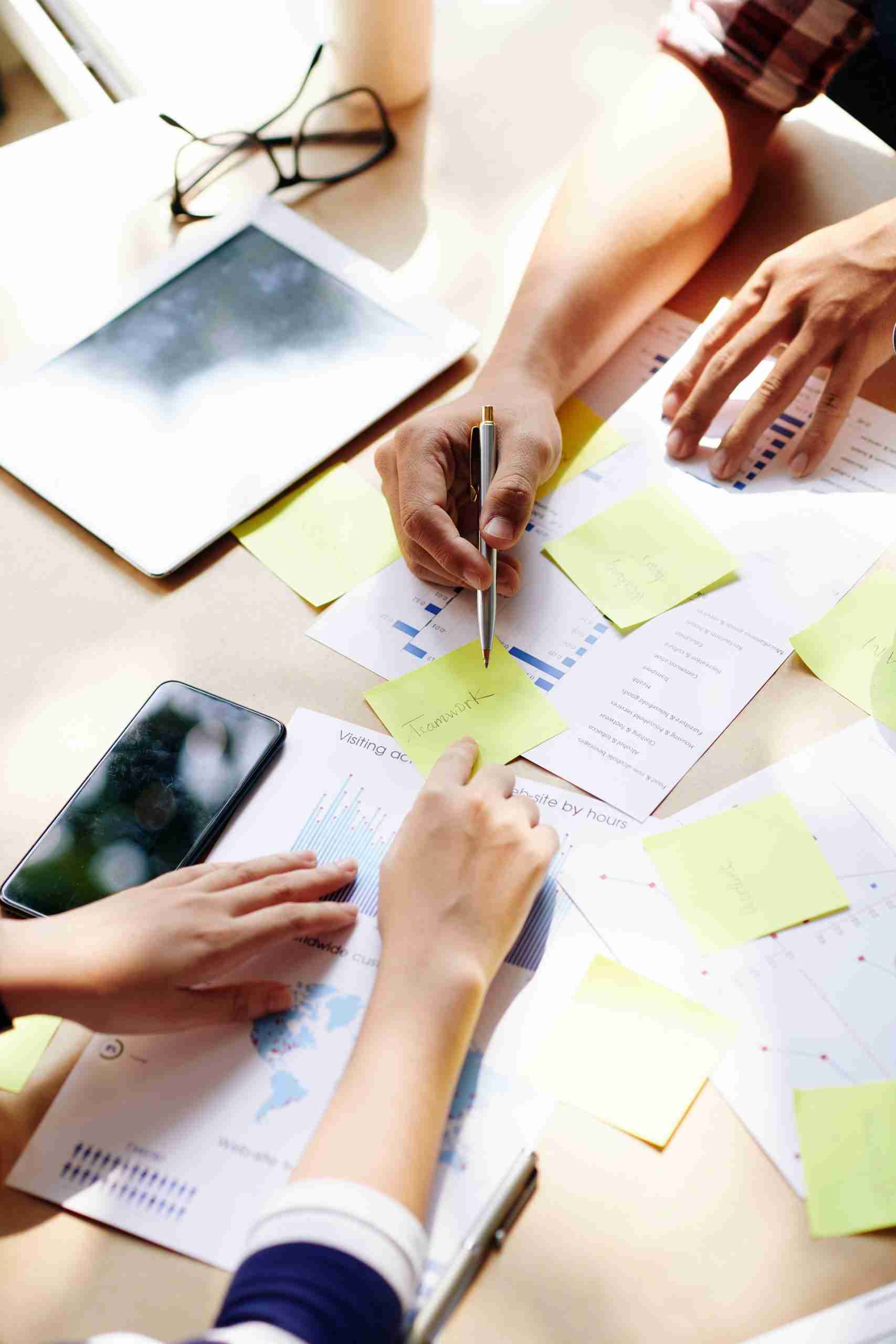 A group of people sitting around a table with sticky notes.